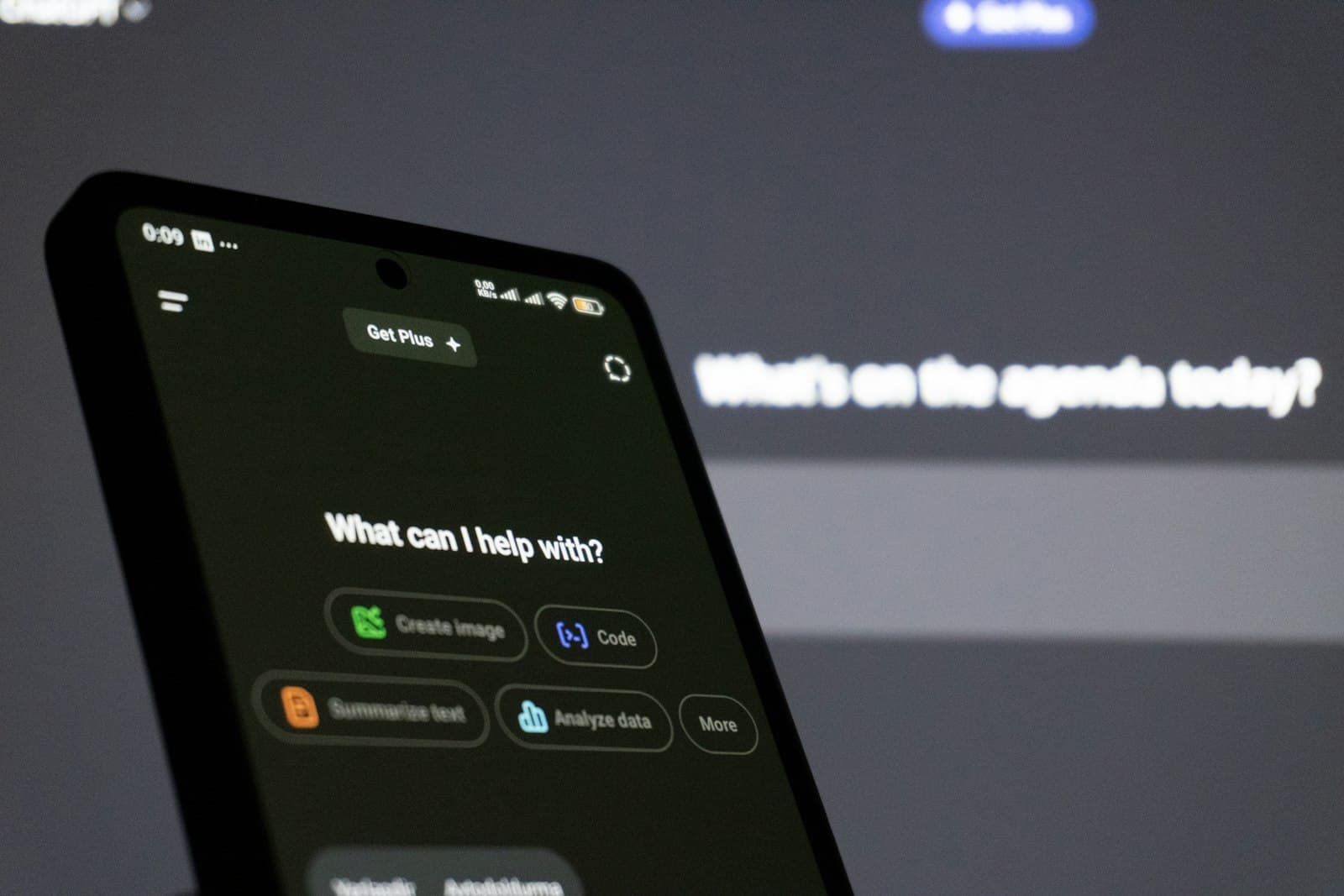 Smartfon z otwartą aplikacją ChatGPT i pytaniem „What can I help with?” na ekranie